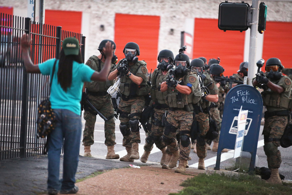 FERGUSON, MO - AUGUST 11: Police force protestors from the business district into nearby neighborhoods on August 11, 2014 in Ferguson, Missouri. Police responded with tear gas and rubber bullets as residents and their supporters protested the shooting by police of an unarmed black teenager named Michael Brown who was killed Saturday in this suburban St. Louis community. Yesterday 32 arrests were made after protests turned into rioting and looting in Ferguson.   Scott Olson/Getty Images/AFP