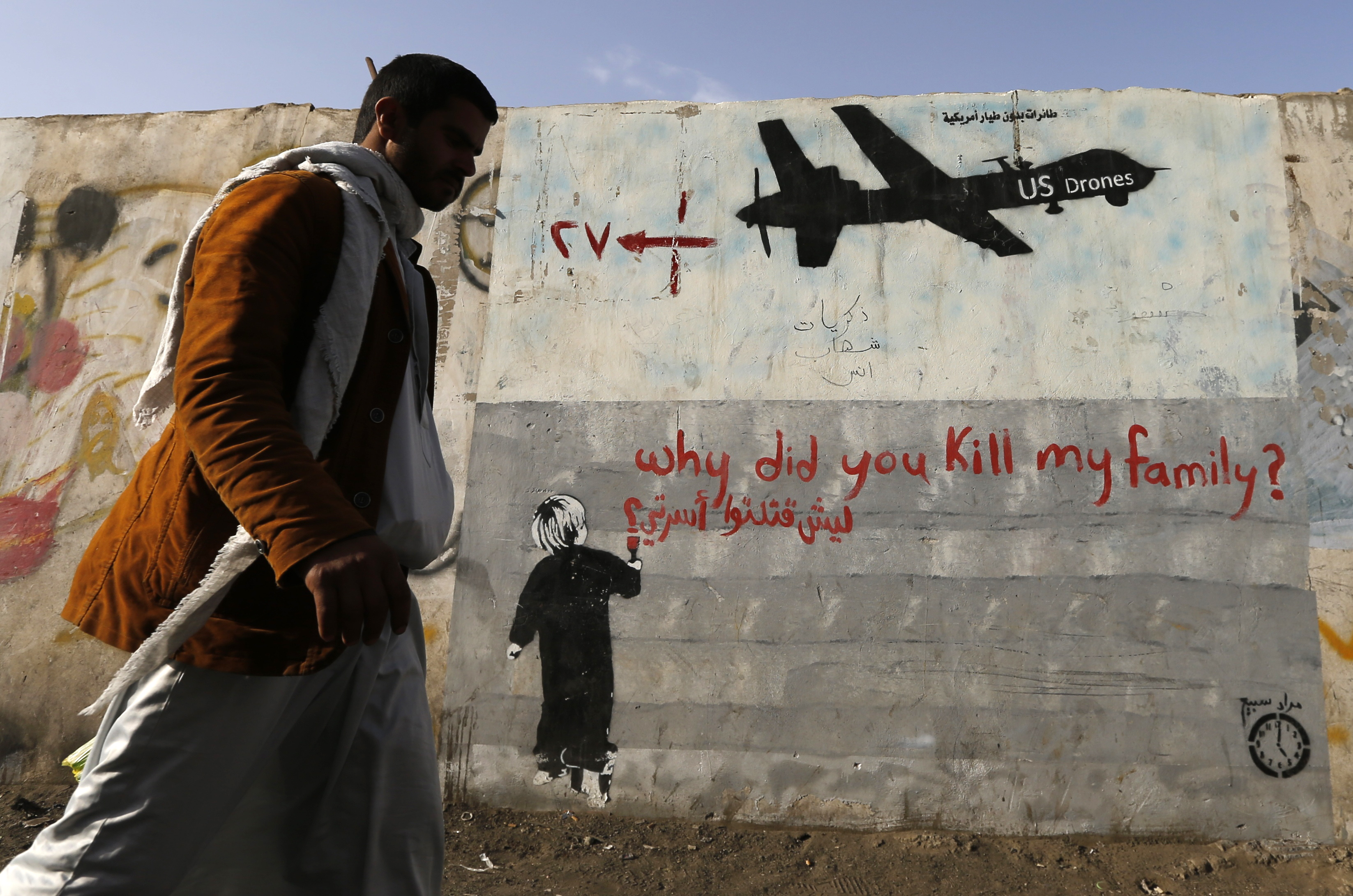 A man walks past a graffiti, denouncing strikes by U.S. drones in Yemen, painted on a wall in Sanaa November 13, 2014. Yemeni authorities have paid out tens of thousands of dollars to victims of drone strikes using U.S.-supplied funds, a source close to Yemen's presidency said, echoing accounts by legal sources and a family that lost two members in a 2012 raid. REUTERS/Khaled Abdullah (YEMEN - Tags: CIVIL UNREST MILITARY POLITICS SOCIETY TPX IMAGES OF THE DAY) - RTR4E1VF