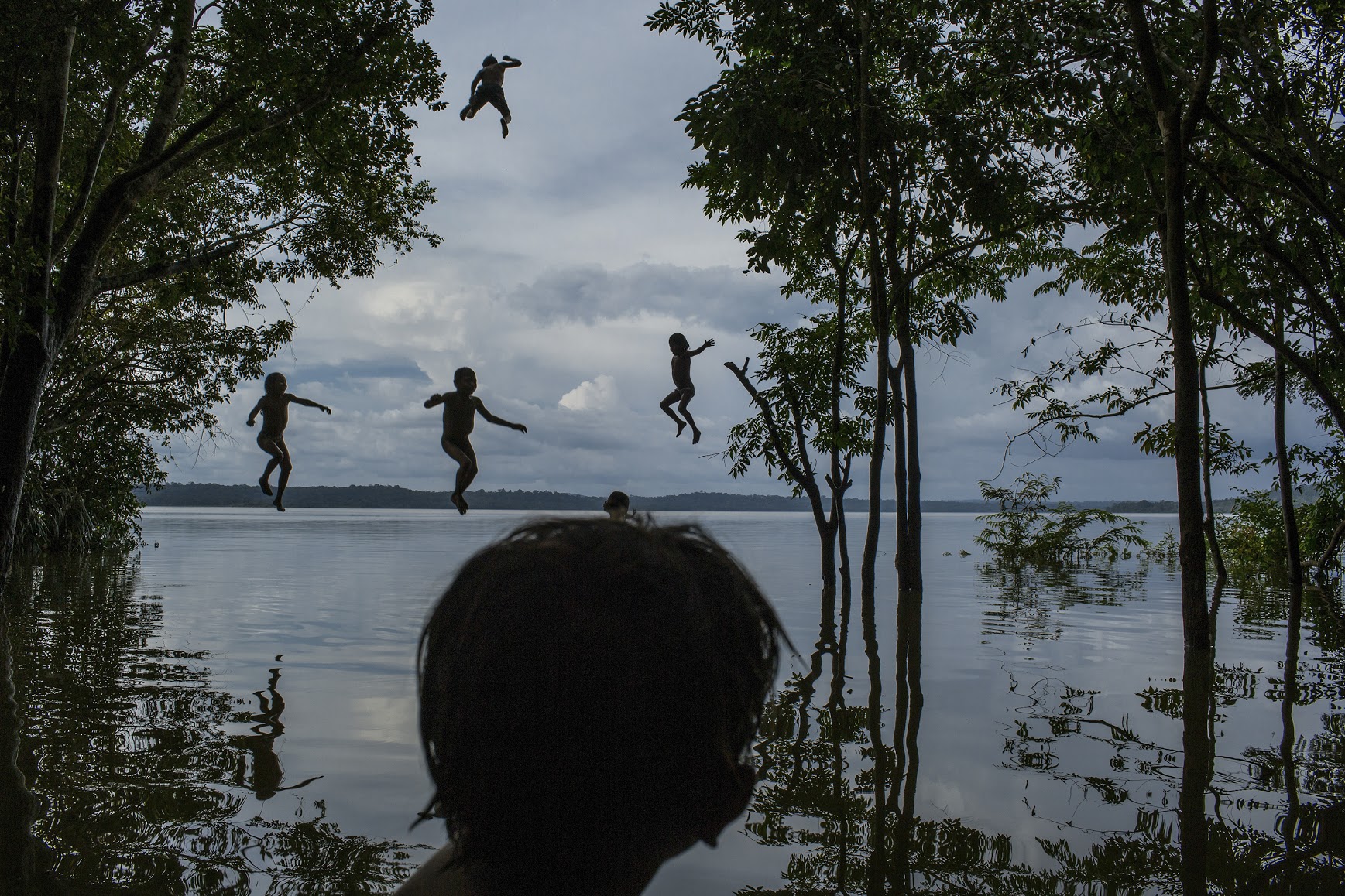 1. Tapajós River, Itaituba, Pará State, Brazil, on February 10, 2015. Indigenous children jump into the water as they play around the Tapajós river, in the Munduruku tribal area called Sawré Muybu.